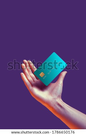 Close up female hand holds levitating template mockup Bank credit card with online service isolated on violet background