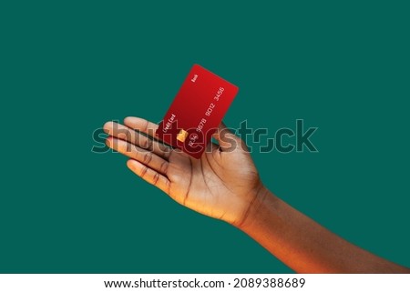 Close up african american female hand and levitating template Bank credit card with online service on green background