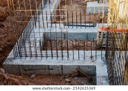 Monolithic foundation with metal reinforcement. Forms vertical formwork structures for the basement of a residential building. Monolithic concrete foundation. Support foundation. Home construction Foto d'archivio © 