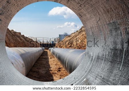 Modern water supply and sewerage system. Underground pipeline works. Water supply and wastewater disposal of a residential city. Close-up of underground utilities. View from the big pipe Foto d'archivio © 