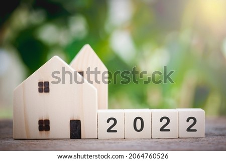 Wooden houses model with wooden block number 2022 and copy space using as background concept to save money buying house, new year property, business, real estate and property concept.