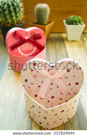 Two heart shaped Valentines Day gift box on old wood. Vintage holiday background.