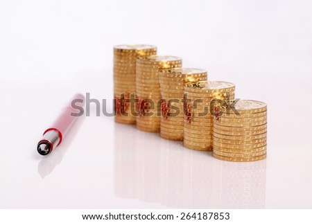 Golden coins and red pen\
Stacks of golden coin and red pen an white background
