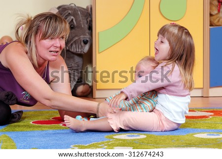 Mom playing with children in nursery