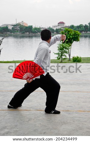 Nakhonsawan,Thailand,30 May 2012 : a teenager play Taichi Fan which is Chinese martial art at Sawan Park,Nakhonsawan,Thailand.