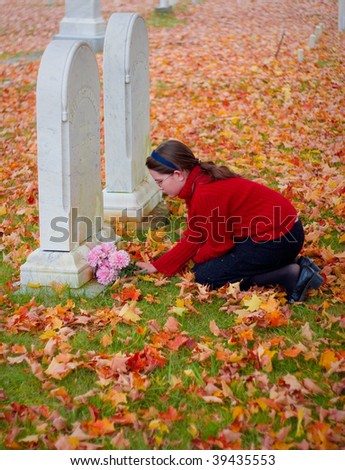 A young girl grieves at a grave