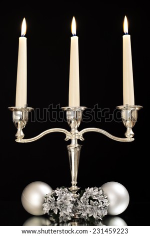 candlestick with three candles and silver ornaments for the Christmas tree as a Christmas and New Year decoration/candlestick with three candles