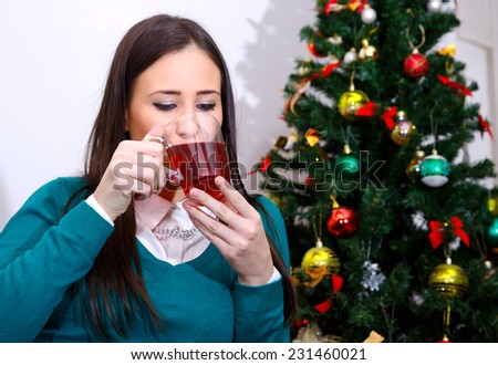 young girl at Christmas drinking a cup of hot tea/Christmas with a cup of tea