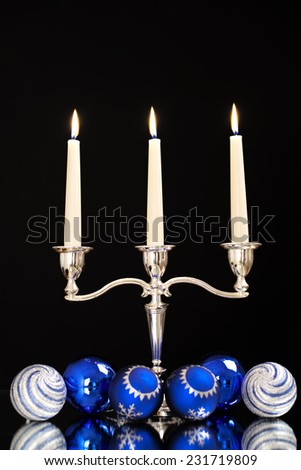 candlestick with three candles and blue balls for the Christmas tree as a Christmas and New Year decoration/Christmas and New Year decoration
