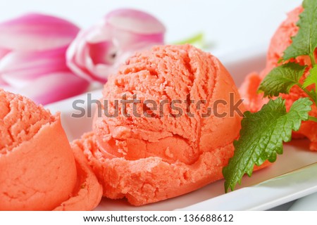 three ice cream scoops in a line decorated with fresh tulip blossoms