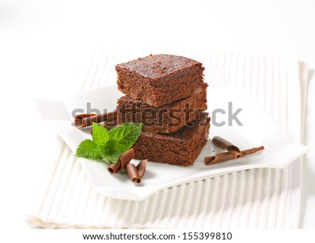 three pieces of brownie cake with chocolate curls