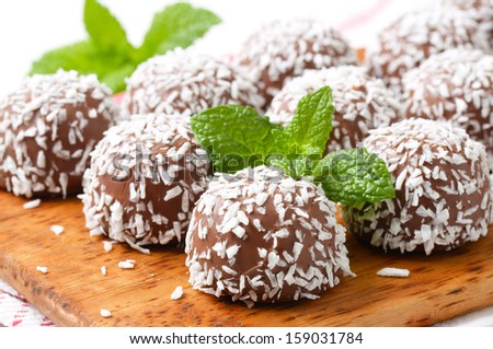 detail of chocolate pralines breaded in a coconut, on a wooden cutting board