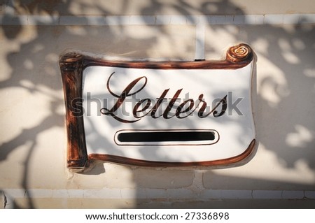Decorative mail slot in a wall