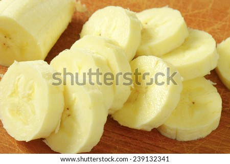 detail of fresh banana slices on wooden cutting board