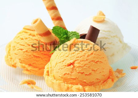 Scoops of ice cream garnished with wafer rolls