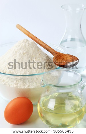 wheat flour,  carafe of cold water, jug of sunflower oil and an egg