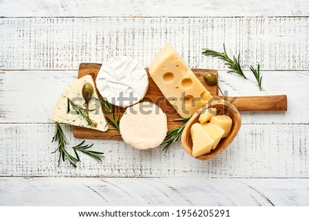 Set or assortment cheeses. Suluguni with spice, camembert, blue cheese, parmesan, maasdam, brie cheese with rosemary and pepper.  Top view. On white wooden old background. Free copy space. Сток-фото © 