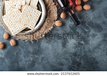 Passover celebration concept. Matzah, red kosher and walnut. Traditional ritual Jewish bread on old  dark grey concrete background. Passover food. Pesach Jewish holiday.  Stock fotó © 