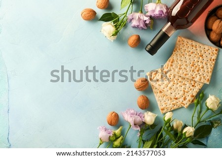 Passover celebration concept. Matzah, red kosher walnut and spring beautiful rose flowers. Traditional ritual Jewish bread on light turquoise or blue background. Passover food. Pesach Jewish holiday. Foto stock © 