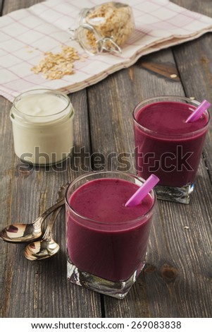 Smoothie made with frozen red berries,milk, and oatmeal in a glasses in wooden background.Selective focus.