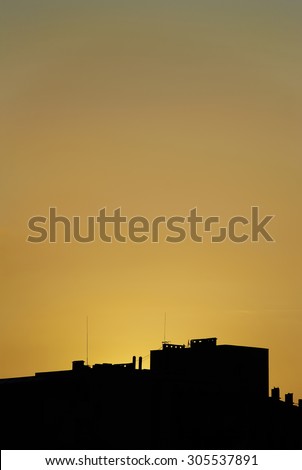 Silhouette of buildings in orange sunset, buildings silhouettes in colourful sunset, evening in the city, flaming red sky at the evening twilight.