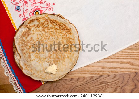 Russian pancakes on a towel. Wooden table, top view.