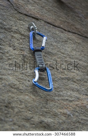 Climbing. A safety bolt with a carbine. Granite wall