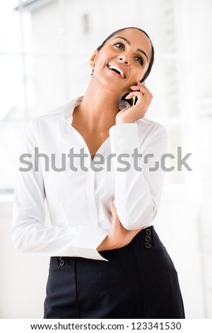 Indian business woman using mobile phone happy