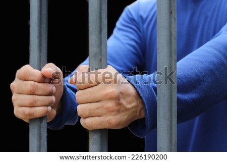 Prisoner hand holding a metal bars