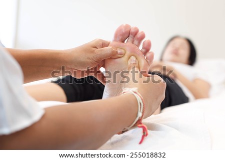 Woman receiving and relaxing foot massage at the health spa