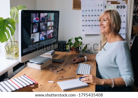 Smiling mature woman having video call via computer in the home office. Online team meeting video conference calling from home. Attractive Businesswoman Telework. Business video conferencing. 