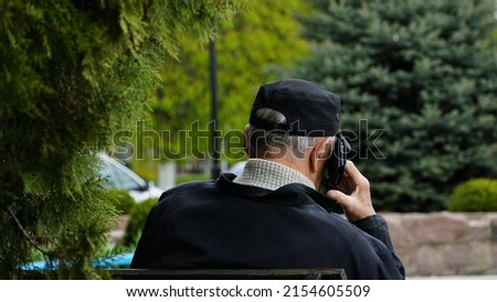 A man speaks on the phone on the street. The phone is attached to the ear. View from the back. n Foto stock © 