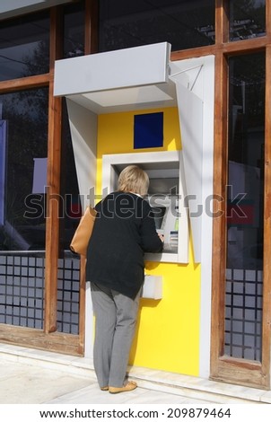 woman using cash machine. ATM. Hole in the wall.