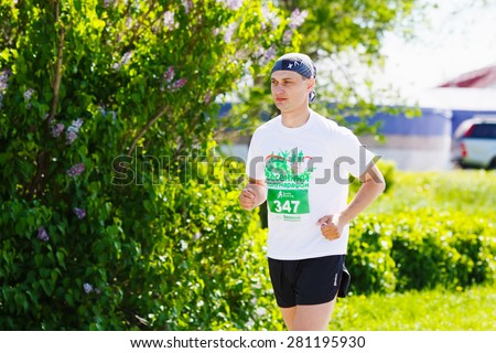 OMSK, RUSSIA - MAY 24 : Marathon runner competes at the Spring Half Marathon 2015 in Omsk, Russia, May 24,  2015. Marathon athletes running on street.