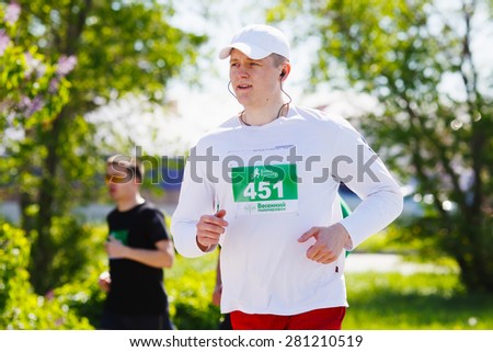 OMSK, RUSSIA - MAY 24 : Marathon runner competes at the Spring Half Marathon 2015 in Omsk, Russia, May 24,  2015. Marathon athletes running on street.