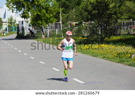 OMSK, RUSSIA - MAY 24 : Marathon runner compete at the Spring Half Marathon 2015 in Omsk, Russia, May 24,  2015. Elderly marathon athletes running on street.