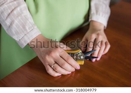 Florist tool in the hands of a woman making a bouquet