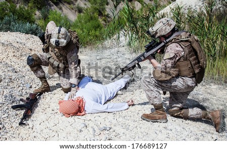 Two US marines making a search of killed muslim warrior