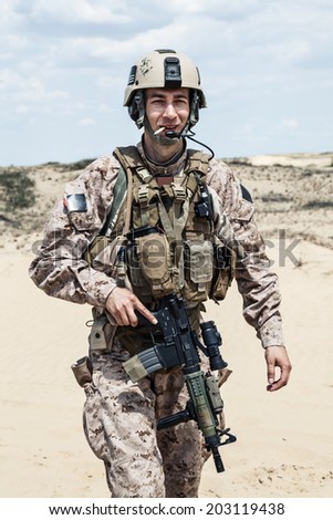 smiling US marine in the desert smoking a cigarette