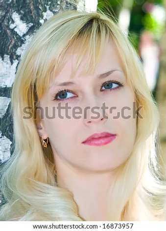 portrait of pretty blonde girl near of birch stem