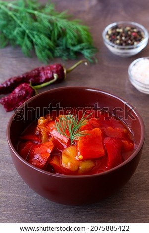 tasty lecho of tomatoes and red peppers with ingredients on the table. lecso national dish of Hungarian cuisine greens in the brown bowl. Hungarian food with copy space. vertical Stock fotó © 