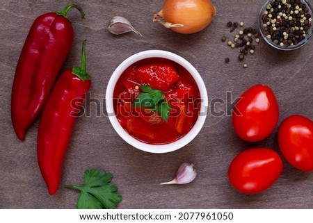 top view of lecho of tomatoes and sweet paprika with ingredients on the table. lecso national dish of Hungarian cuisine with pepper and tomato, greens on the white bowl. Hungarian food. copy space. Stock fotó © 