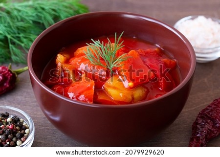 tomato sauce in a bowl. close-up lecho of tomatoes and red peppers with ingredients on the table. lecso national dish of Hungarian cuisine greens in the brown bowl. Hungarian food. copy space. Stock fotó © 