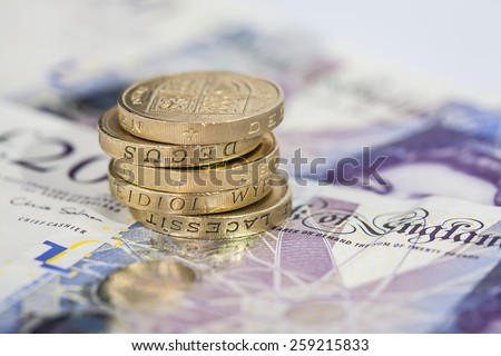 Stack of Pound Coins on Twenty Pound Notes