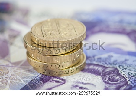 Pile of UK Pound Coins on Twenty Pound Notes