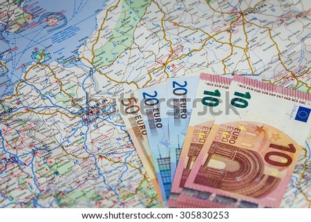 Stack of money, Euro notes and map of Europe over Berlin, Germany