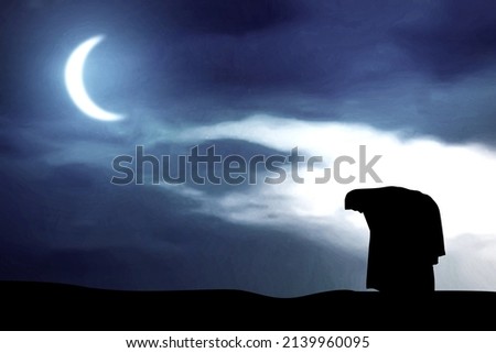 Silhouette of Muslim woman in veil in praying position (salat) with the night scene background Imagine de stoc © 