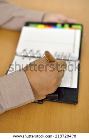 Business man writing on agenda over office desk