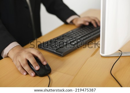 Business man typing with keyboard on wooden desk