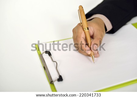 Business man writing on clipboard on the desk